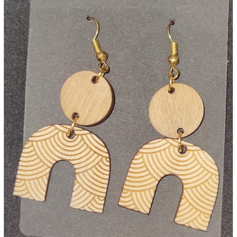 Boucles d'oreilles pendantes en bois avec gravures feuilles, ondes et motifs cellulaires.